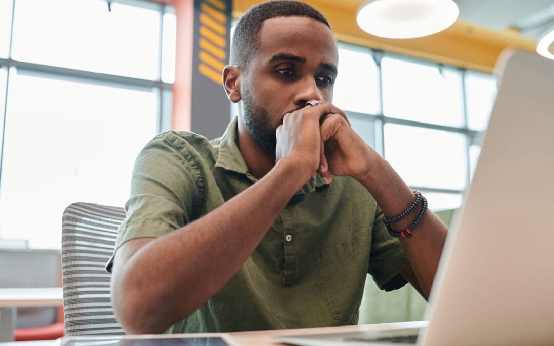 Business owner looking thoughtfully at a laptop screen while reviewing AI search results